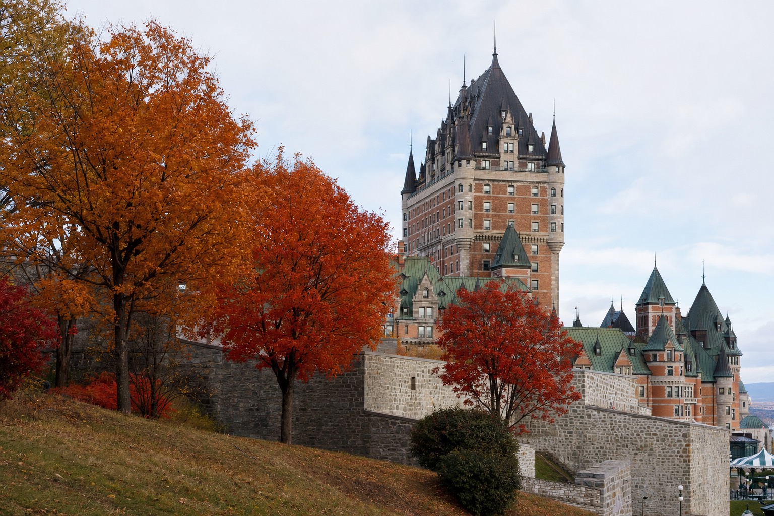 Red and gold maples along the fortification walls of Old Quebec with the Château Frontenac behind on an October morning