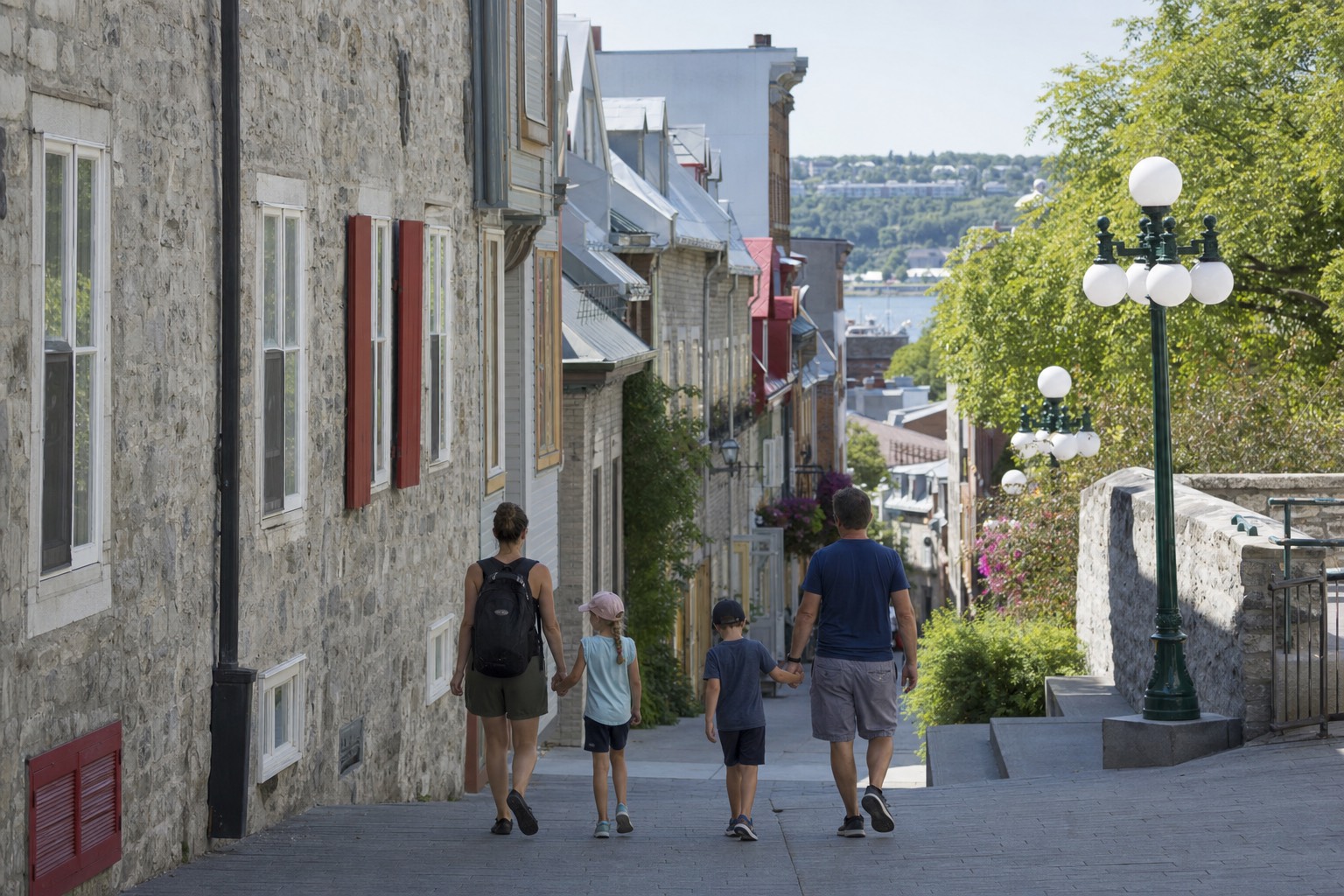 Family with two children walking down rue du Petit-Champlain in Old Quebec on a summer afternoon