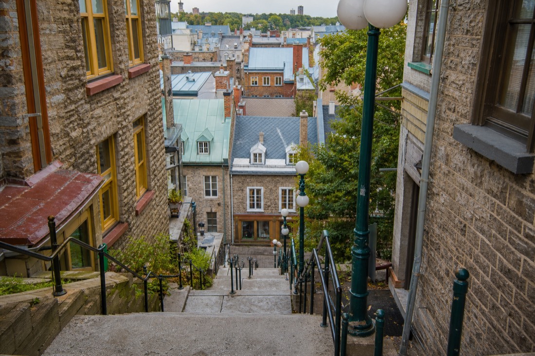Stone steps of the Casse-Cou stairway descending toward the rooftops of Petit Champlain in Quebec City
