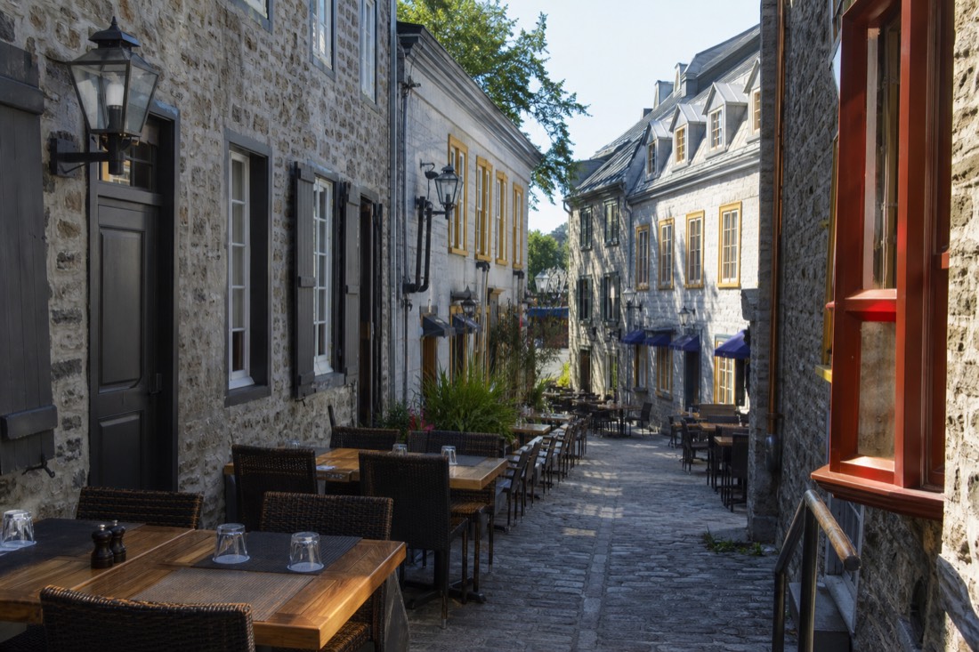 Lunch tables on a cobbled lane in Lower Town Quebec City filled with midday visitors