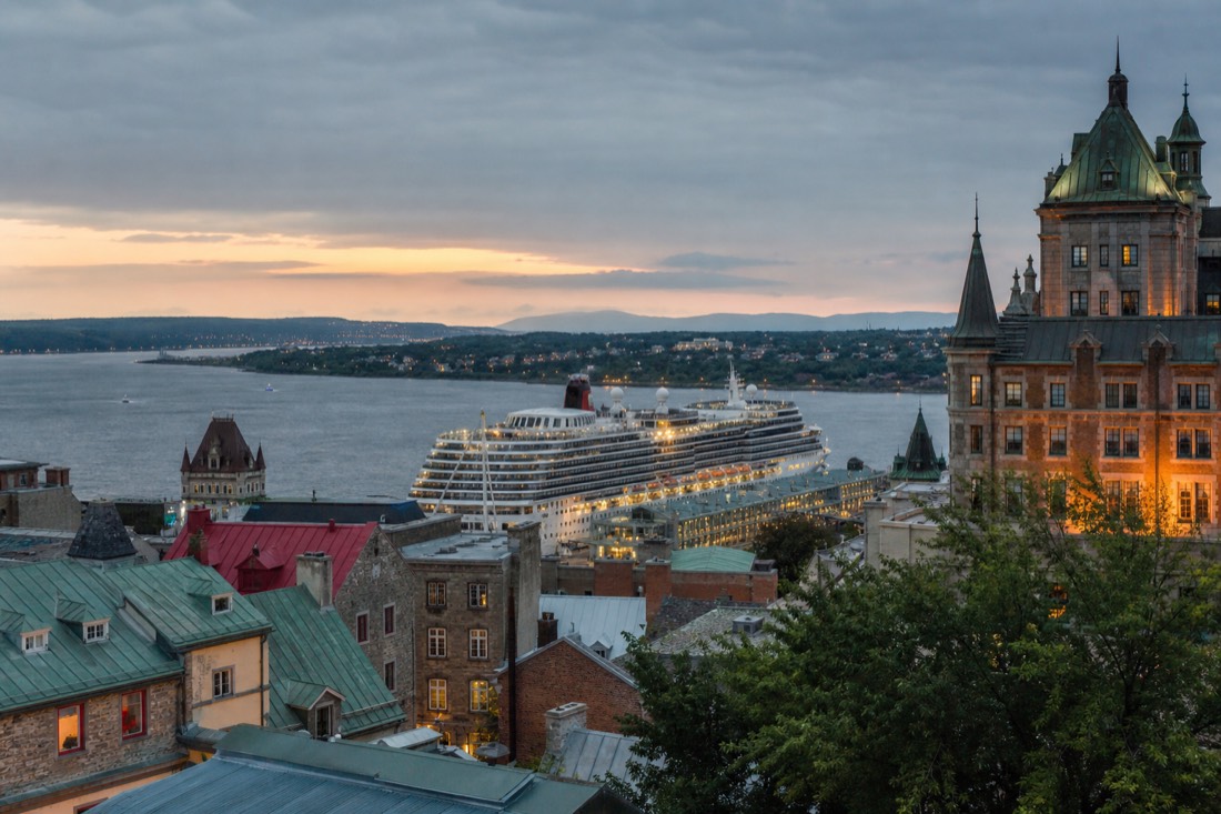 Evening view over the Old Port of Quebec City with a cruise ship at the wharf preparing to depart