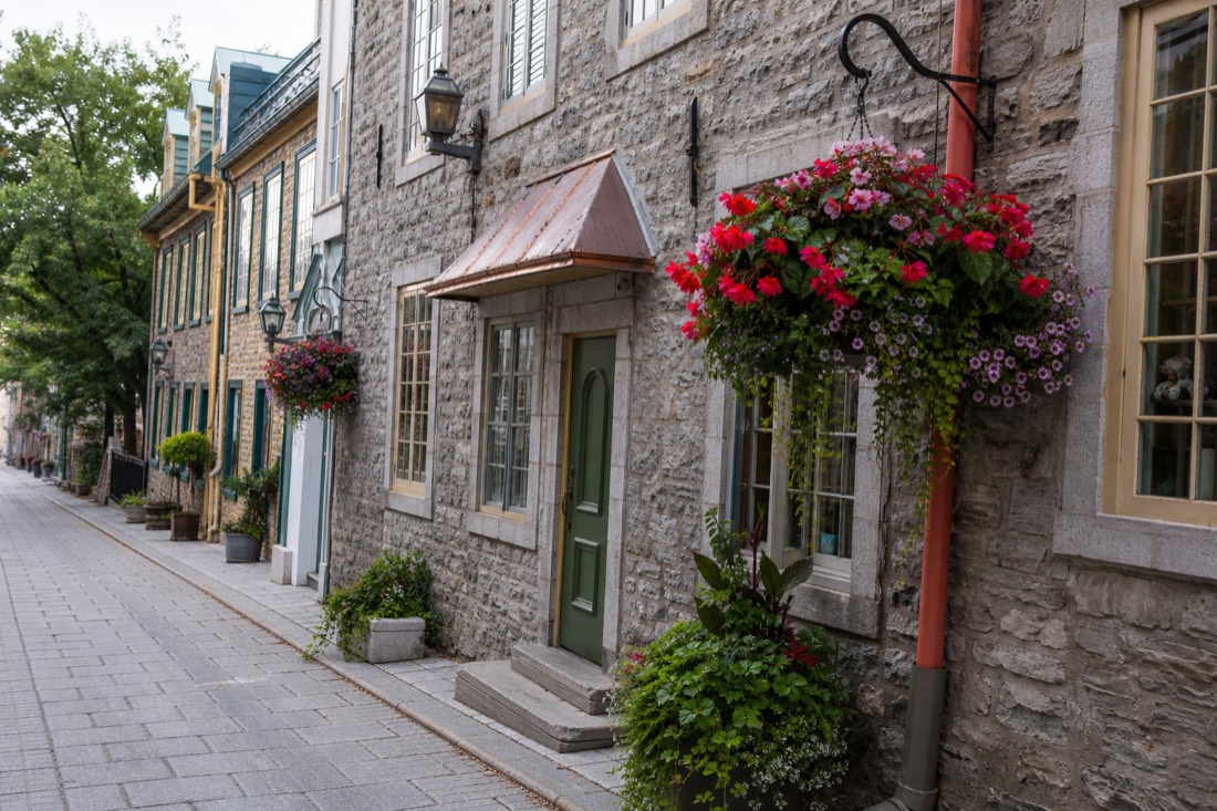 Petit Champlain street with stone shopfronts and hanging flower baskets in Lower Town Quebec