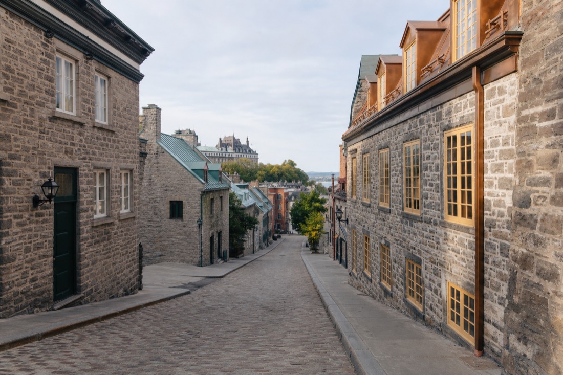 Cobblestone street in Old Quebec with stone buildings, a route landmark on a self-guided walking tour map